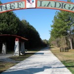 Chief Ladiga Trail sign hangs above trail where Silver Comet Trail & Chief Ladiga Trail meet